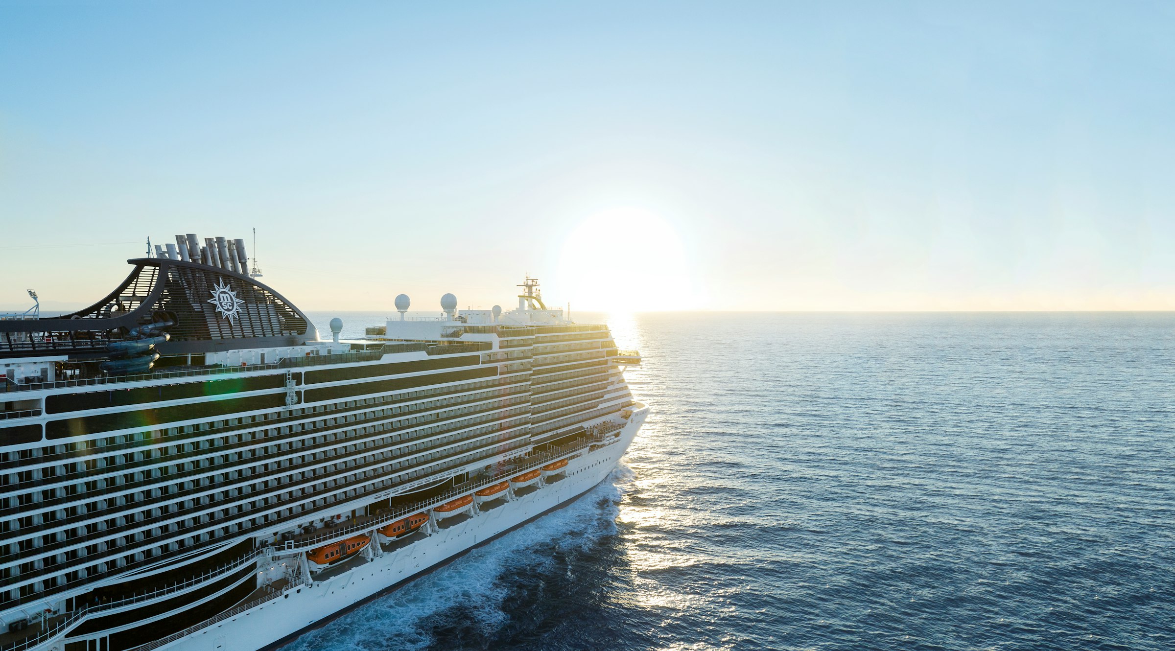 Cruise ship sailing the open ocean toward the sun